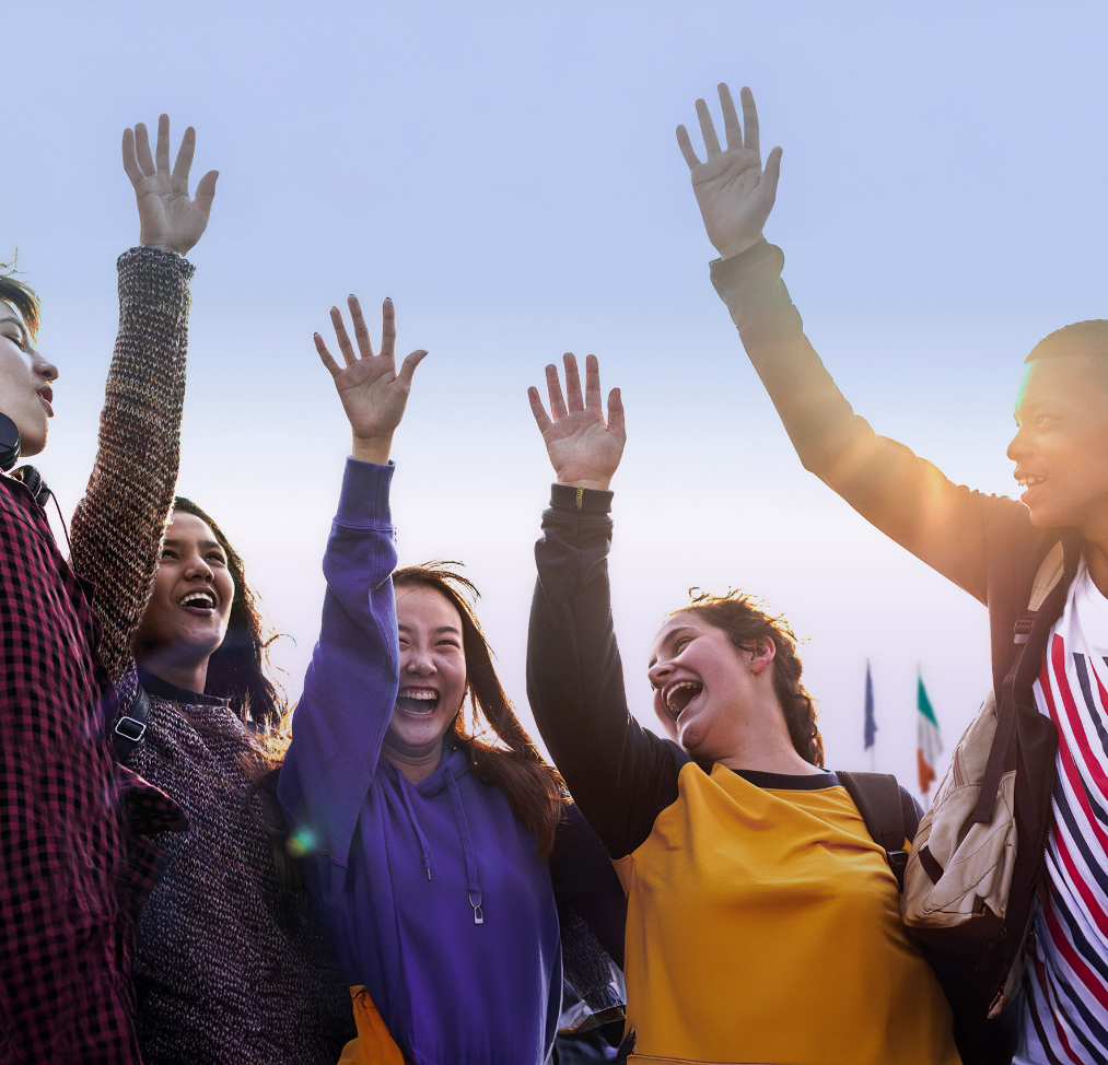 planet youth smiling teenagers raising hands in the air